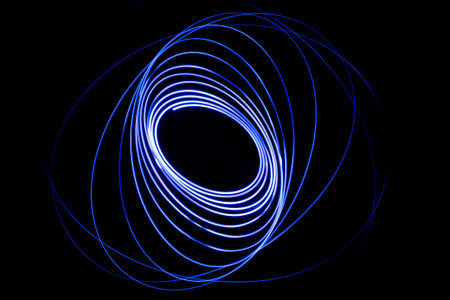 Light streaks in the shape of circles. A trace of a moving light point. Dark background.の素材 [FY310160796600]