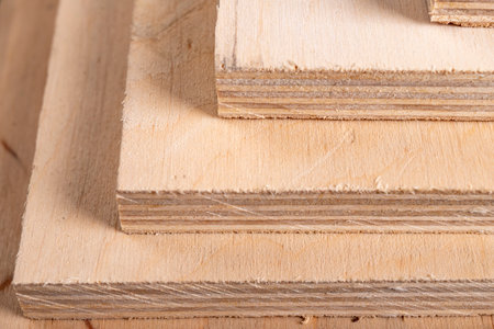 Plywood panels stacked on top of each other. Materials for carpenters for the construction of furniture. Dark background.の写真素材