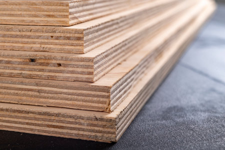 Plywood panels stacked on top of each other. Materials for carpenters for the construction of furniture. Dark background.の写真素材