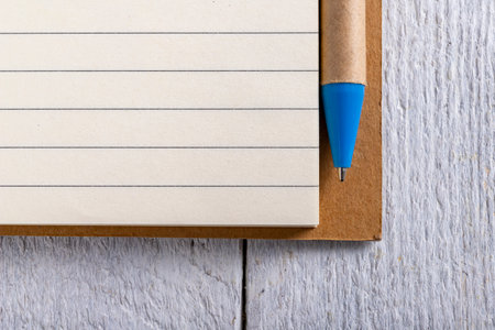 A clean, blank lined notebook and a pen. A place to write down your notes. Light background.の写真素材