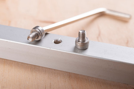 Tighten the small screws with an Allen key. Locksmith works in the workshop. Light background.の写真素材