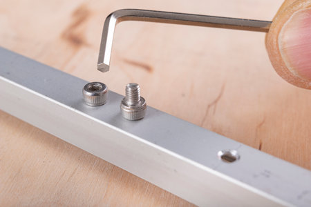 Tighten the small screws with an Allen key. Locksmith works in the workshop. Light background.の写真素材