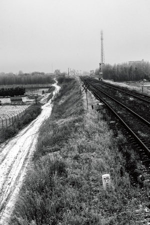 A field road along the railway embankment. Railway traction near the railway station. Winter season.の写真素材
