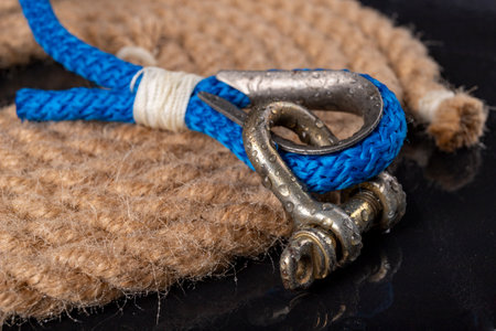 Wet shackle and rope. Accessories for sea wolves on the table. Dark background.の写真素材