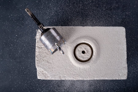 Drilling large diameter holes in brick. Holes for mounting electrical boxes. Dark background.の写真素材