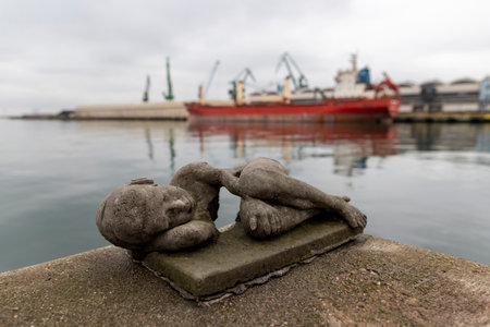 Gdynia, Pomeranian Poland - January, 08, 2020: A small figurine of a Polish artist. Symbolic figurine of a child on the wharf in the port. Winter season.のeditorial素材
