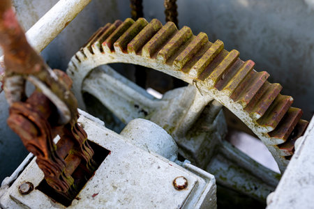 Large gears in an old gearbox. Steel structure to transfer rotational energy. Light background.の写真素材