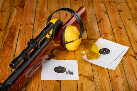 Pneumatic weapons and shooting accessories. Shield hearing protectors on the shooting range. Dark background.の写真素材