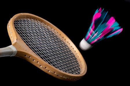 Wooden badminton racket and shuttlecock with feathers. Accessories for games in a sports hall. Dark background.の写真素材