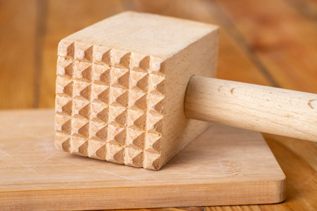Wooden meat grinder on a chopping board. Wooden kitchen utensils on the kitchen table. Light background.の写真素材