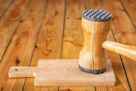Wooden meat grinder on a chopping board. Wooden kitchen utensils on the kitchen table. Light background.の写真素材