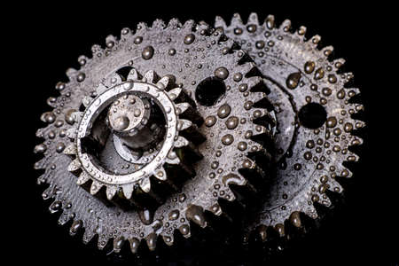 Water drops on gear wheels. Wet spare parts for an internal combustion engine. Dark background