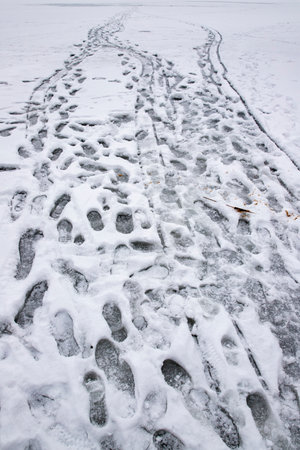 Traces of people on the ice. Snow-covered ice on a frozen lake. Winter season.の写真素材