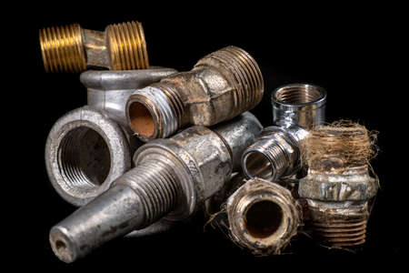 Old metal plumbing fittings. Accessories for minor repairs of water installations. Dark background.の写真素材