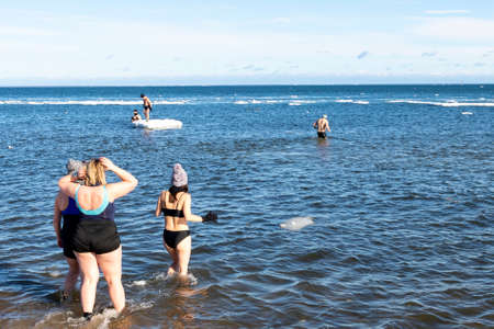 Mechelinki, Pomorskie Poland - February, 14, 2021: Cold bath in ice water. People swimming in the sea in winter. Winter season.のeditorial素材