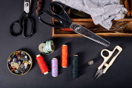 Threads on the table in the tailor's workshop. Accessories necessary for tailoring. Dark background.の写真素材