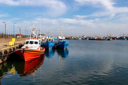 Wladyslawowo, Pomorskie Poland - February, 24, 2021: Fishing boats moored in the port. Port infrastructure in a small town in Central Europe. Season - spring.のeditorial素材