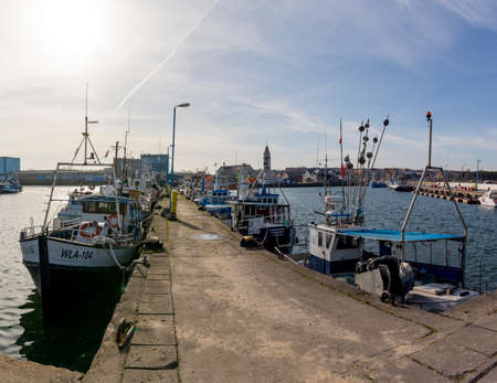 Wladyslawowo, Pomorskie Poland - February, 24, 2021: Fishing boats moored in the port. Port infrastructure in a small town in Central Europe. Season - spring.のeditorial素材