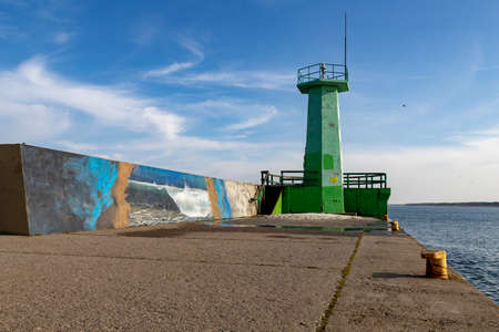 Wladyslawowo, Pomeranian Voivodeship Poland - February, 24, 2021: Breakwater head in a fishing port. Port infrastructure in a small town by the sea. Spring season.のeditorial素材