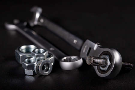 A screw and a metal wrench in the workshop. Accessories for mounting metal elements. Dark background.の写真素材