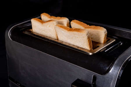 A modern toaster for toasting bread. Domestic electrical appliance for making casseroles. Dark background.の写真素材
