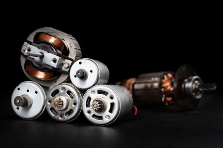 Small electric motors for driving domestic appliances. Electric devices stacked on a table. Dark background.の写真素材