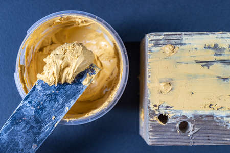 Mixing the filling for raw wood in a workshop.