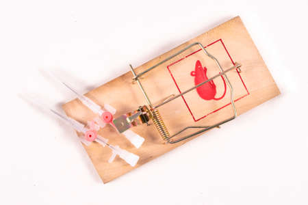 Medical venflon placed in a mousetrap. Medical accessories as a trap for patients. Light background.の写真素材