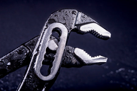 Wet adjustable wrench used in assembly works. Accessories for plumbers. Dark background.の写真素材