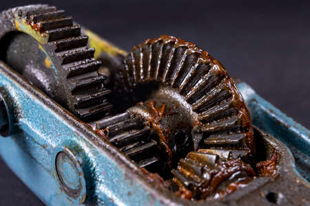Bevel gear lubricated with grease. A mechanism for transmitting torque in a mechanical device. Dark background.の写真素材