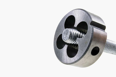 Die for cutting threads in a screw during operation. Mechanical accessories in a locksmith's workshop. Isolated background.の写真素材