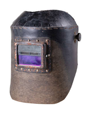 Old helmet for a welder with automatic dimming. Personal protection accessories in a locksmith's workshop. Isolated background.の写真素材
