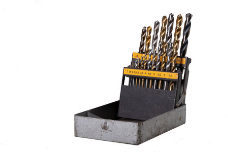 Old box with metal drill bits. Tools for making holes in the locksmith's workshop. Isolated background.の写真素材