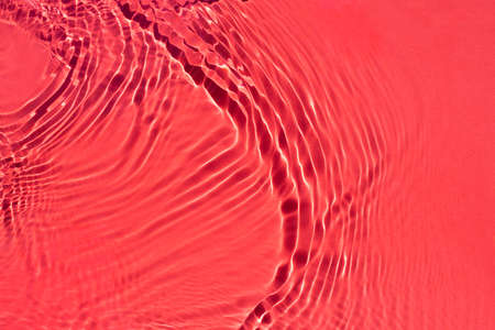 Water spills on a light red background. Natural sunlight and shade. Beautiful streaks. Summer mood....