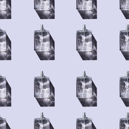 Transparent bottles of perfume on an light grey seamless background. Natural sunlight and shadows. Beautiful sunshine. Clear glass without lid.の写真素材