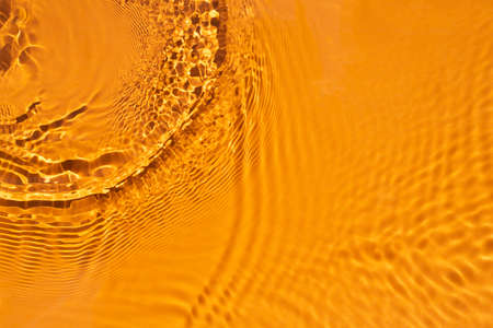 Aqua waves on orange background. Light and shadows. Water spills on a light orange background....
