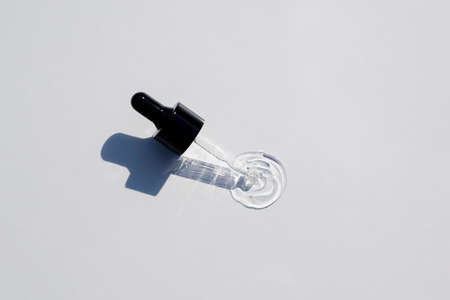 Open cap with dropper pipette with serum. Light background with daylight and the appearance of the texture of the gel.Skincare products , natural cosmetic. Beauty concept for face and body careの写真素材