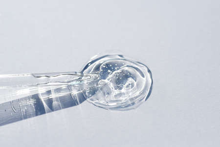 Pipette close-up on a light background in soft focus. Beautiful shadow in the sunlight. Skincare products , natural cosmetic. Beauty concept for face and body careの写真素材