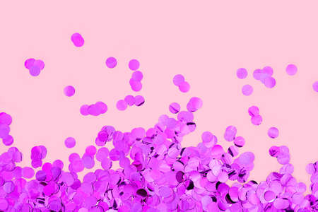 Violet round confetti on pink background. Festive day backdrop. Flat lay style with minimalistic design. Template for banner or party invitationの写真素材