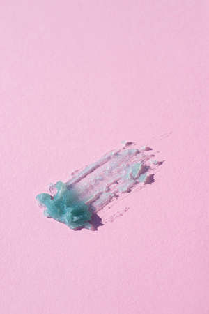 Cosmetic smear. Appearance of the texture of the blue tansy oil on pink background. Natural skincare...