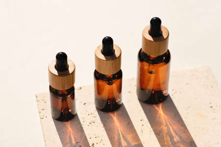 Amber glass dropper bottles with bamboo lid on stone plate. Skincare products , natural cosmetic....