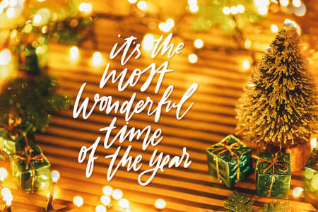 Christmas or New Year background with place for text. Green gift boxes kraft striped background. Festive decor backdrop with lights. Atmospheric soft focus photoの写真素材