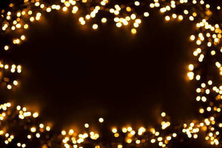 Beautiful natural bokeh of the yellow lights. Abstract Christmas New Year backdrop for text or advertising. Template for banner or party invitationの写真素材