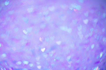 Natural purple bokeh of lights in the form of a heart, blurred out of focus background. Abstract beautiful backdrop for text or advertising. Postcard with love in light gentle colorsの写真素材