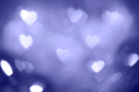 Natural purple bokeh of lights in the form of a heart, blurred out of focus background. Abstract beautiful backdrop for text or advertising. Postcard with love in light gentle colorsの写真素材