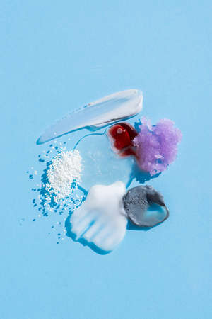 Cosmetic smears and drops. Appearance of the texture of the cream, oil and granules on a blue background. Natural skincare products. Beauty concept for face and body careの写真素材
