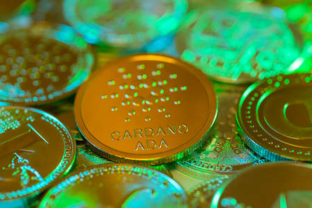 Cardano golden coin against the background of other coins. Electronic virtual cryptocurrency for...