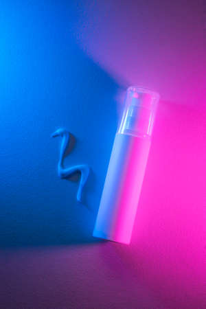 Plastic white tube for lotion and the appearance of the texture of the cream with beautiful purple and pink color. Skincare sunscreen cosmetic in top view. Beauty concept for face body careの写真素材