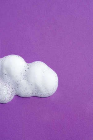 Cosmetic smears and drops. Appearance of the texture the foam on purple background. Natural skincare...
