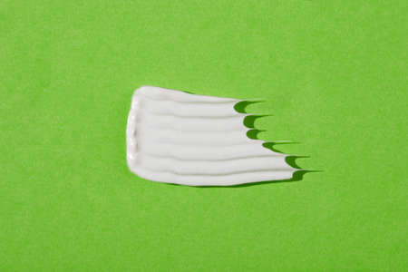 A smear of cream or face mask. The appearance of the texture of the cream on green background....